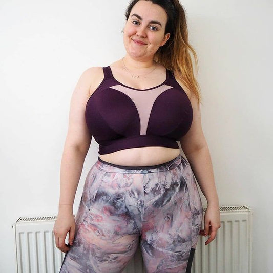 Woman wearing a Royce Aerocool sports bra and patterned leggings against a plain wall.