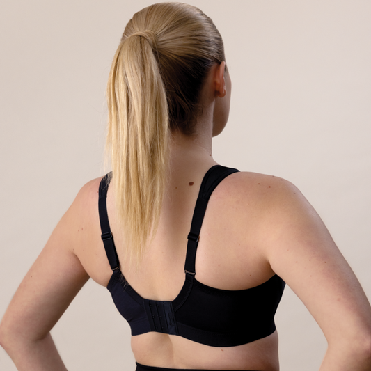 A woman wearing a black Shock Absorber Active D+ Classic Support Sports Bra showing the back and the H strap design