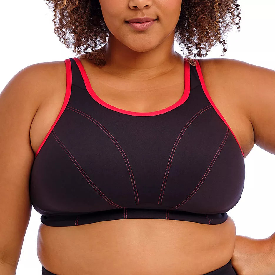 Black sports bra with red trim worn by a person on a white background
