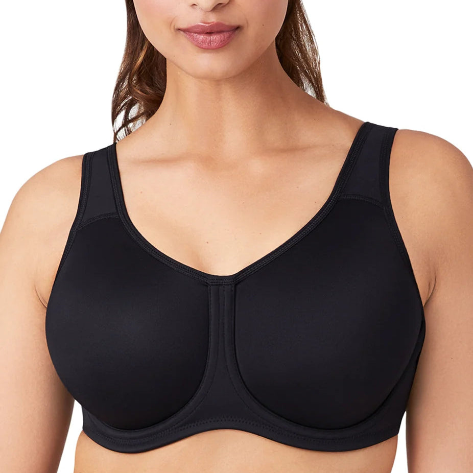 A close-up of a woman wearing a black seamless underwire bra with a wide shoulder strap and molded cups, shown against a plain white background.