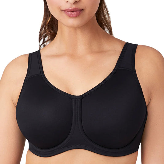 A close-up of a woman wearing a black seamless underwire bra with a wide shoulder strap and molded cups, shown against a plain white background.